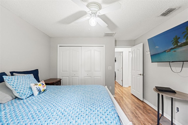 15364 Mount Sparrow Rd, Weeki Wachee, FL 34614 - bedroom with light wood-type flooring, a textured ceiling, a closet, and a ceiling fan