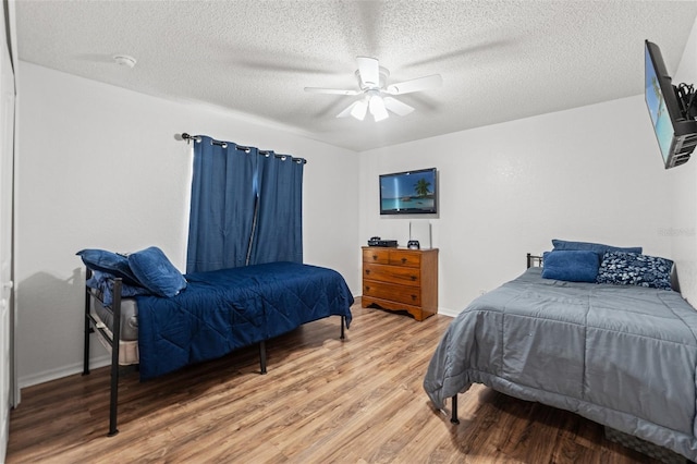 15364 Mount Sparrow Rd, Weeki Wachee, FL 34614 - bedroom with light wood-style flooring, a textured ceiling, and a ceiling fan