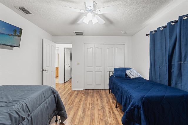 15364 Mount Sparrow Rd, Weeki Wachee, FL 34614 - bedroom with light wood-style flooring, a textured ceiling, ceiling fan, and a closet