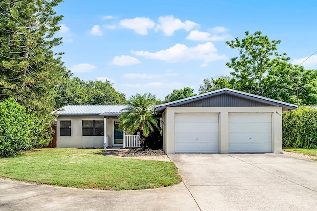 4130 W Main St, Mims, FL 32754 - ranch-style home with stucco siding, a front lawn, a garage, and a metal roof