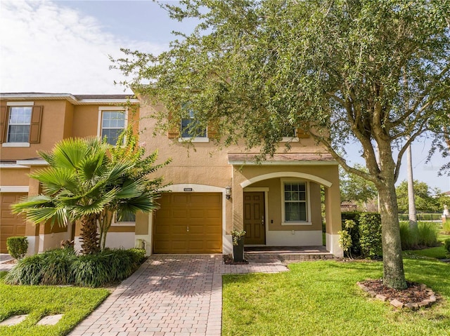 11081 Savannah Landing Cir, Orlando, FL 32832 - view of front of house with an attached garage, stucco siding, decorative driveway, and a front yard