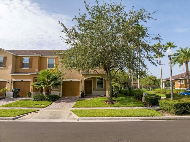 11081 Savannah Landing Cir, Orlando, FL 32832 - view of front facade with a garage, stucco siding, driveway, and a front yard