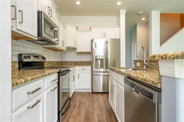 11081 Savannah Landing Cir, Orlando, FL 32832 - kitchen with stainless steel appliances, white cabinetry, light stone counters, and recessed lighting