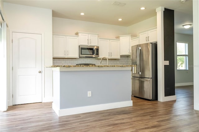 11081 Savannah Landing Cir, Orlando, FL 32832 - kitchen with stainless steel appliances, decorative backsplash, white cabinetry, light stone countertops, and recessed lighting