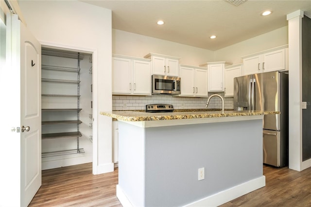 11081 Savannah Landing Cir, Orlando, FL 32832 - kitchen featuring appliances with stainless steel finishes, white cabinetry, tasteful backsplash, light wood-type flooring, and recessed lighting