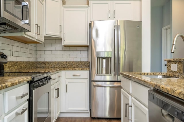 11081 Savannah Landing Cir, Orlando, FL 32832 - kitchen featuring appliances with stainless steel finishes, backsplash, white cabinetry, and stone countertops