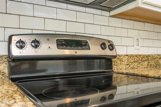 11081 Savannah Landing Cir, Orlando, FL 32832 - kitchen view of stainless steel electric stove, backsplash, and light stone countertops