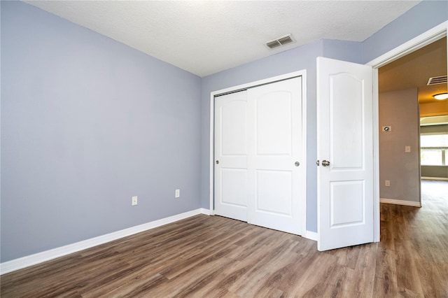 11081 Savannah Landing Cir, Orlando, FL 32832 - unfurnished bedroom with wood finished floors, a closet, and a textured ceiling