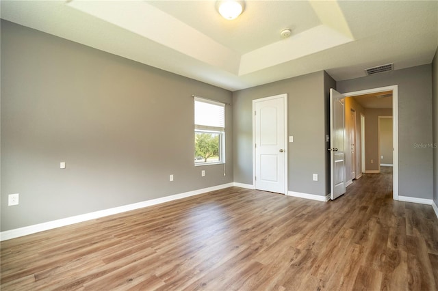 11081 Savannah Landing Cir, Orlando, FL 32832 - unfurnished bedroom featuring wood finished floors and a tray ceiling