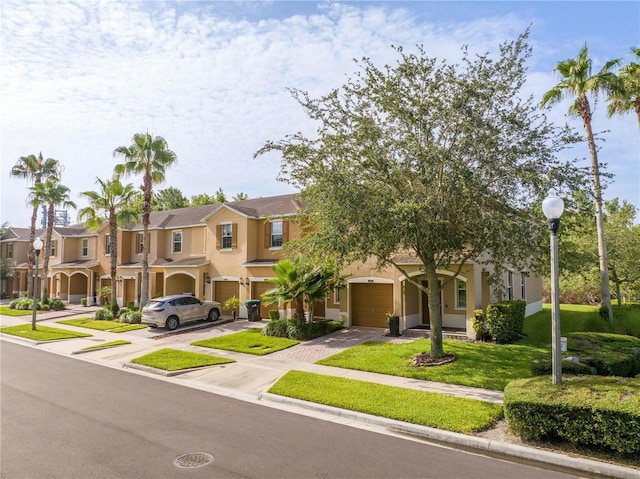11081 Savannah Landing Cir, Orlando, FL 32832 - view of property with an attached garage, driveway, a residential view, and stucco siding