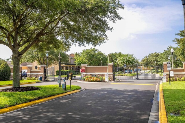 11081 Savannah Landing Cir, Orlando, FL 32832 - view of asphalt road featuring street lights, a gate, and curbs