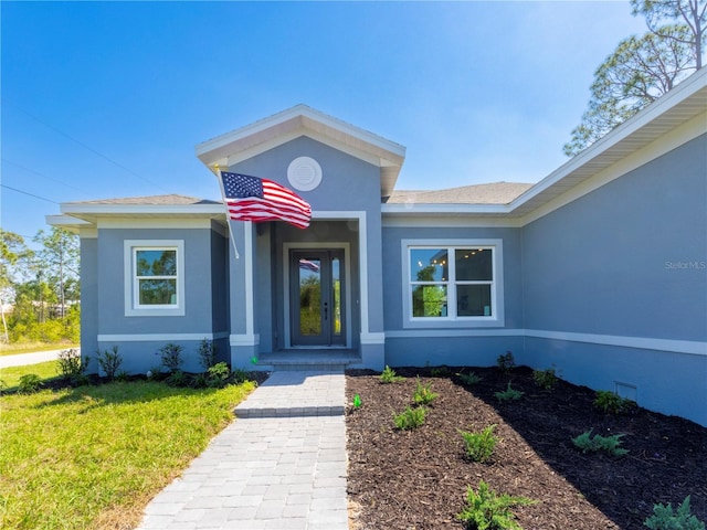 14073 Naylor Ave, Port Charlotte, FL 33981 - view of exterior entry with stucco siding and a yard