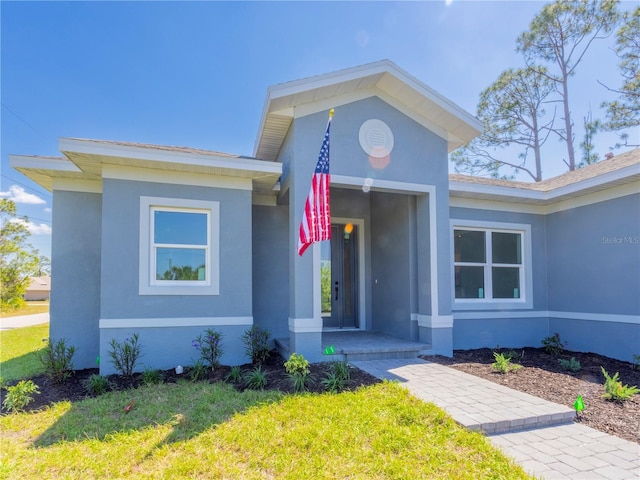 14073 Naylor Ave, Port Charlotte, FL 33981 - property entrance with stucco siding and a lawn