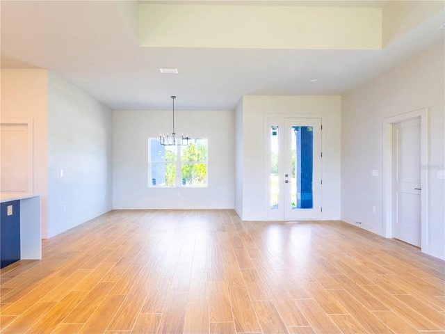 14073 Naylor Ave, Port Charlotte, FL 33981 - unfurnished living room featuring a chandelier and light wood-style floors