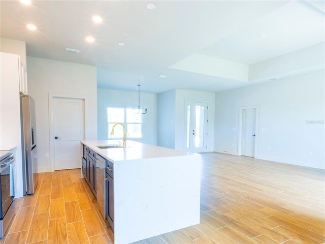 14073 Naylor Ave, Port Charlotte, FL 33981 - kitchen with stainless steel fridge with ice dispenser, light wood finished floors, light countertops, recessed lighting, and hanging light fixtures