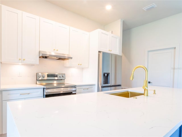 14073 Naylor Ave, Port Charlotte, FL 33981 - kitchen with under cabinet range hood, stainless steel appliances, light stone counters, and white cabinetry