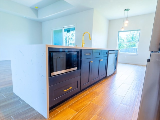 14073 Naylor Ave, Port Charlotte, FL 33981 - kitchen featuring appliances with stainless steel finishes, light wood finished floors, decorative light fixtures, and light countertops