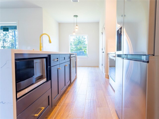 14073 Naylor Ave, Port Charlotte, FL 33981 - kitchen featuring stainless steel appliances, light wood-type flooring, light countertops, and pendant lighting