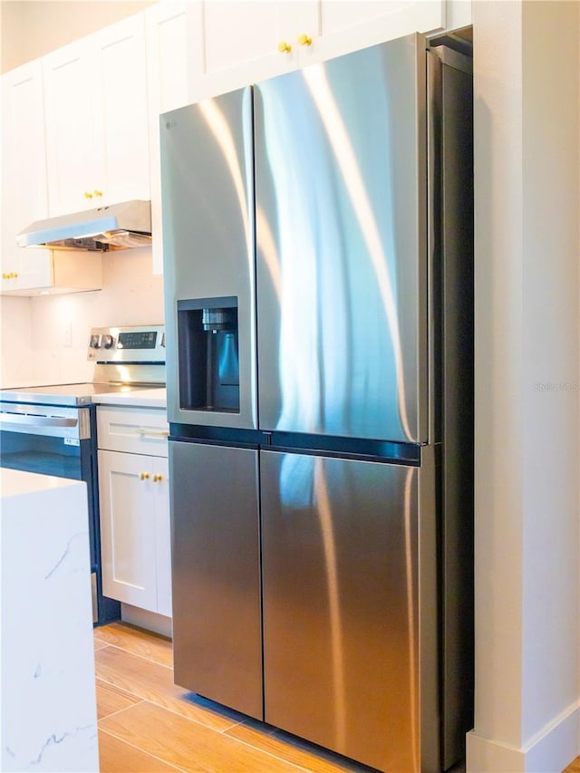 14073 Naylor Ave, Port Charlotte, FL 33981 - kitchen with appliances with stainless steel finishes, under cabinet range hood, white cabinets, light countertops, and light wood-type flooring