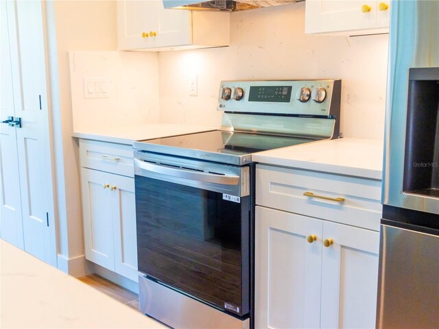 14073 Naylor Ave, Port Charlotte, FL 33981 - kitchen featuring electric stove, fridge, light countertops, and white cabinetry