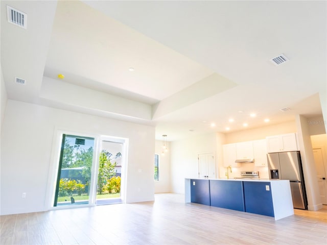 14073 Naylor Ave, Port Charlotte, FL 33981 - kitchen with stainless steel fridge with ice dispenser, white cabinetry, an island with sink, a raised ceiling, and recessed lighting