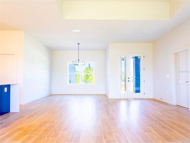 14073 Naylor Ave, Port Charlotte, FL 33981 - unfurnished living room with a chandelier and light wood finished floors