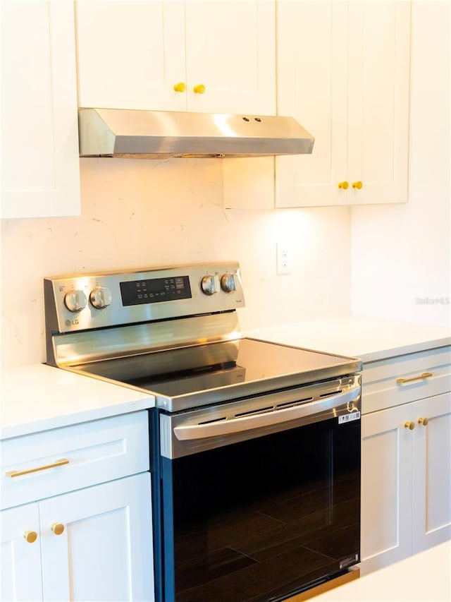 14073 Naylor Ave, Port Charlotte, FL 33981 - kitchen with stainless steel electric stove, under cabinet range hood, white cabinets, and light countertops