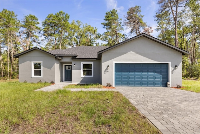 17445 SW 41st Cir, Ocala, FL 34473 - ranch-style home featuring an attached garage, decorative driveway, stucco siding, roof with shingles, and a front lawn