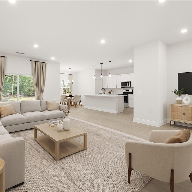 17445 SW 41st Cir, Ocala, FL 34473 - living room with recessed lighting, light wood finished floors, and a chandelier