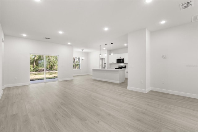 17445 SW 41st Cir, Ocala, FL 34473 - unfurnished living room with recessed lighting, light wood-type flooring, and a chandelier