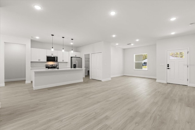17445 SW 41st Cir, Ocala, FL 34473 - unfurnished living room with recessed lighting and light wood-type flooring
