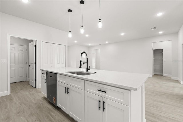 17445 SW 41st Cir, Ocala, FL 34473 - kitchen with dishwasher, light wood finished floors, white cabinets, decorative light fixtures, and a center island with sink