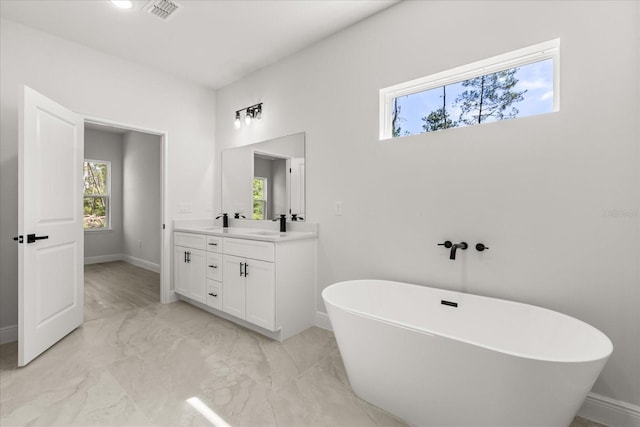 17445 SW 41st Cir, Ocala, FL 34473 - bathroom featuring double vanity, a freestanding tub, and marble finish floors