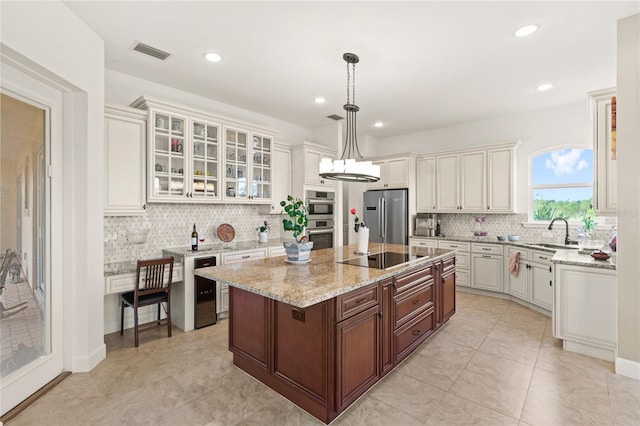 13023 Sweet Hill Rd, Polk City, FL 33868 - kitchen with stainless steel appliances, decorative backsplash, glass insert cabinets, a kitchen island, and light stone countertops