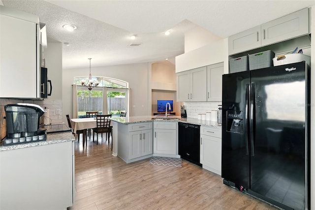 171 Cedarpark Ln, Davenport, FL 33837 - kitchen featuring black appliances, a peninsula, lofted ceiling, a chandelier, and decorative backsplash