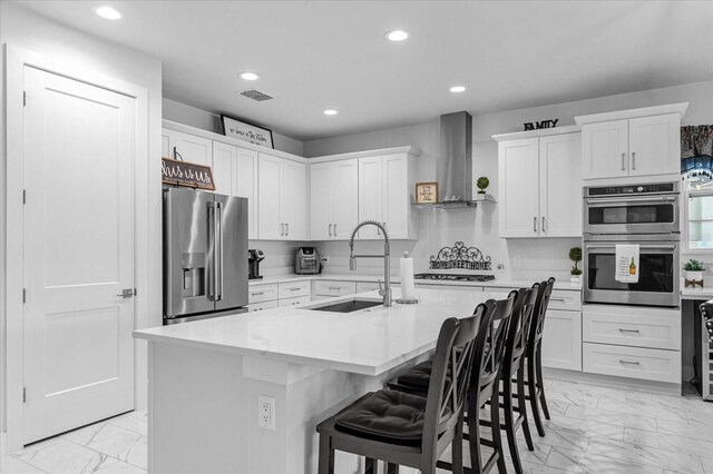 7454 Gathering Dr, Reunion, FL 34747 - kitchen with appliances with stainless steel finishes, light marble finish floors, wall chimney exhaust hood, recessed lighting, and white cabinetry