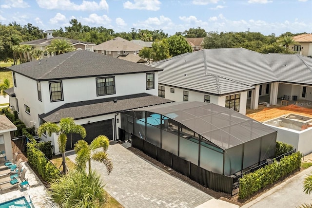 7454 Gathering Dr, Reunion, FL 34747 - back of house featuring stucco siding, an attached garage, decorative driveway, and a residential view