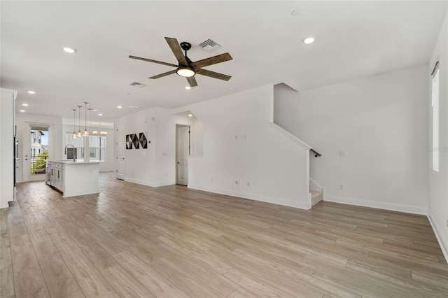 8484 Sperry St, Orlando, FL 32827 - unfurnished living room with ceiling fan, stairs, a chandelier, light wood-style flooring, and recessed lighting