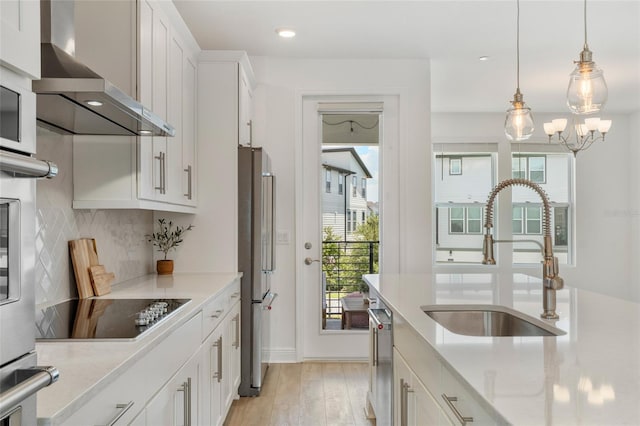 8484 Sperry St, Orlando, FL 32827 - kitchen with wall chimney range hood, freestanding refrigerator, black electric cooktop, plenty of natural light, and recessed lighting