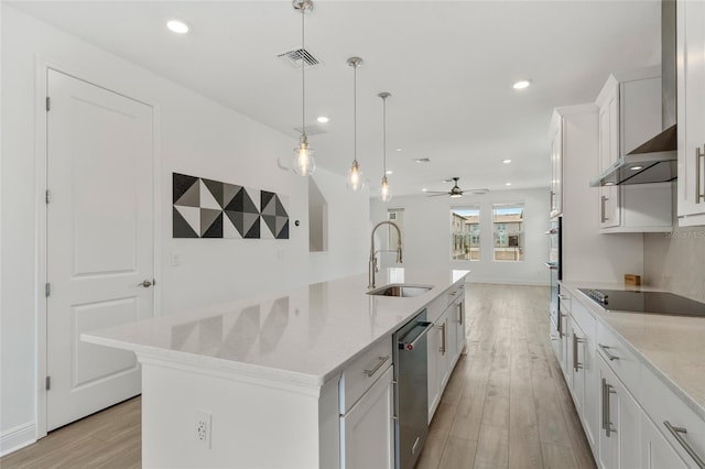 8484 Sperry St, Orlando, FL 32827 - kitchen with appliances with stainless steel finishes, wall chimney range hood, light wood-type flooring, white cabinetry, and recessed lighting
