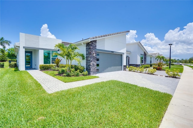 11695 SW Viridian Blvd, Port St Lucie, FL 34987 - modern home with stone siding, a front lawn, and decorative driveway