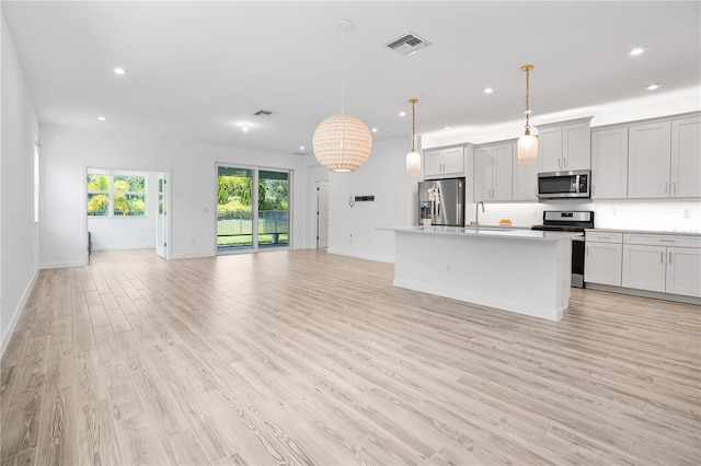 11695 SW Viridian Blvd, Port St Lucie, FL 34987 - kitchen with appliances with stainless steel finishes, open floor plan, recessed lighting, light wood-type flooring, and an island with sink