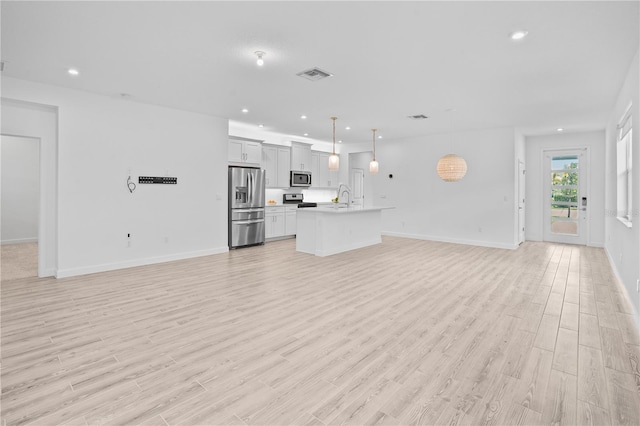 11695 SW Viridian Blvd, Port St Lucie, FL 34987 - unfurnished living room with light wood-style floors and recessed lighting
