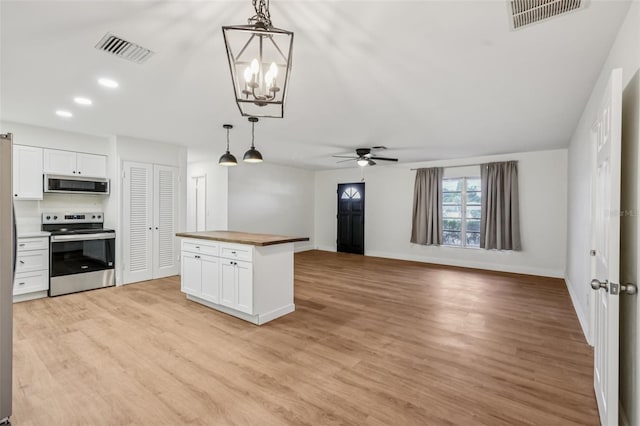 1320 E Lombardy Dr, Deltona, FL 32725 - kitchen with stainless steel appliances, butcher block countertops, white cabinets, and light wood-type flooring