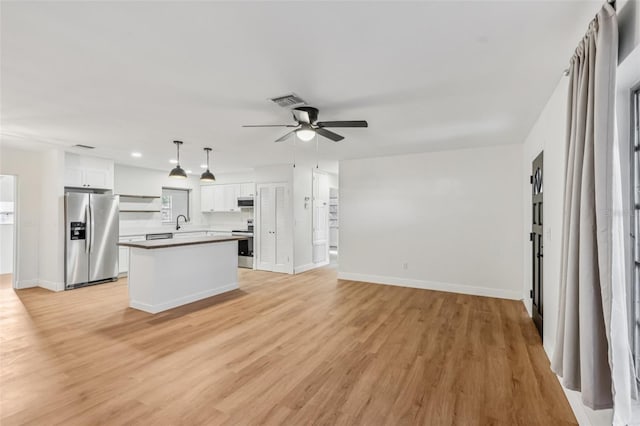 1320 E Lombardy Dr, Deltona, FL 32725 - kitchen with stainless steel refrigerator with ice dispenser, stove, ceiling fan, white cabinetry, and light wood finished floors