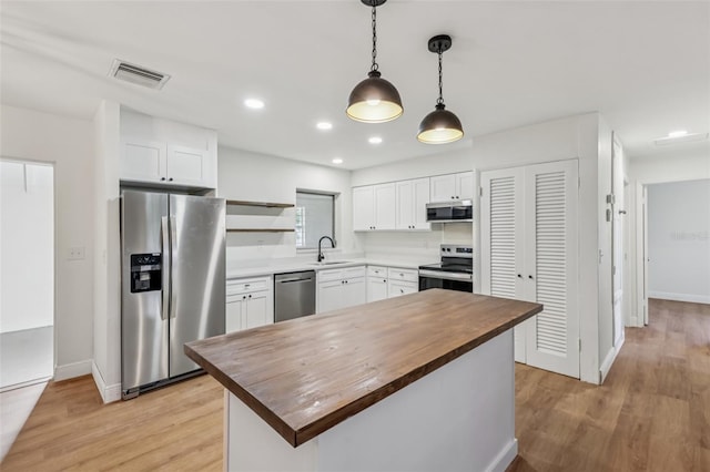 1320 E Lombardy Dr, Deltona, FL 32725 - kitchen featuring stainless steel appliances, butcher block countertops, white cabinets, and recessed lighting