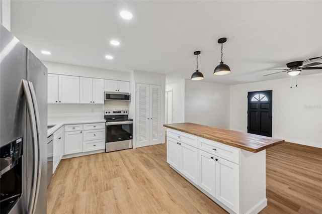 1320 E Lombardy Dr, Deltona, FL 32725 - kitchen featuring stainless steel appliances, wooden counters, light wood-style flooring, ceiling fan, and white cabinetry