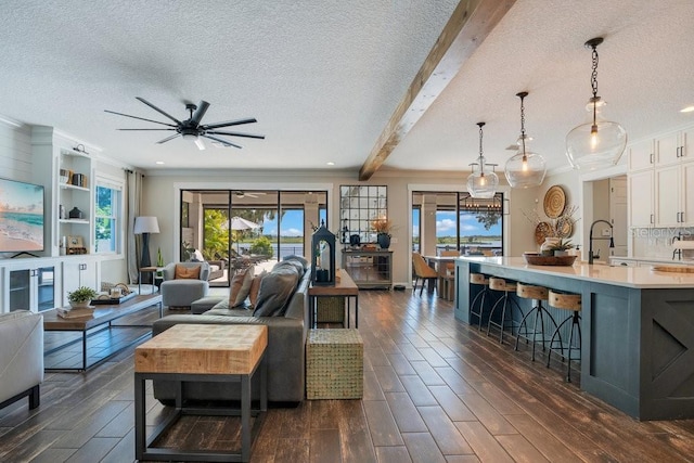 15787 Tangerine Dream Ct, Winter Garden, FL 34787 - living area featuring a ceiling fan, a textured ceiling, dark wood-type flooring, crown molding, and beam ceiling