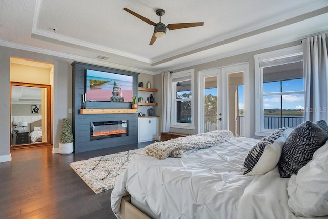 15787 Tangerine Dream Ct, Winter Garden, FL 34787 - bedroom with access to exterior, ornamental molding, dark wood finished floors, a glass covered fireplace, and a raised ceiling
