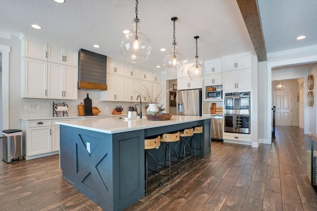 15787 Tangerine Dream Ct, Winter Garden, FL 34787 - kitchen featuring premium range hood, stainless steel appliances, dark wood-style floors, white cabinets, and a textured ceiling